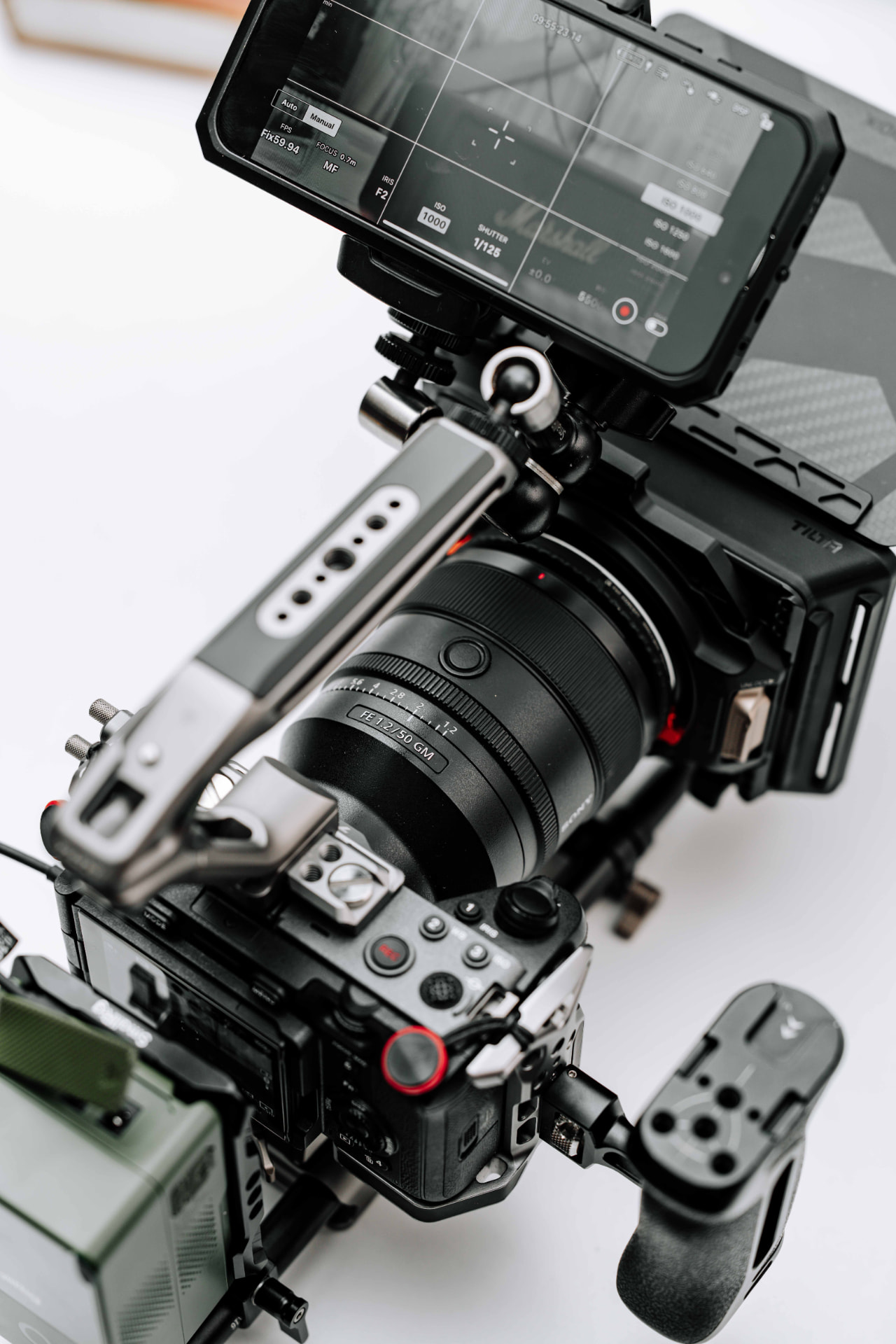 Cameraopstelling met lens, matte box en monitor van bovenaf gefotografeerd op een lichte ondergrond